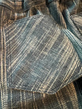 Load image into Gallery viewer, closeup of the denim fabric pocket on the back of the jeans showing the bias design of the fabric and double stitching