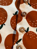 Load image into Gallery viewer, Closeup detail of natural wood buttons down the front of the organic corduroy vest