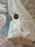 Load image into Gallery viewer, Closeup of the rolled cuff and sleeve tab showing the top stitch detail and wood button