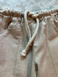 Load image into Gallery viewer, a closeup of the natural linen pant to show the elastic waist and drawstring