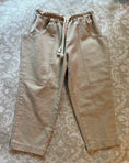 Load image into Gallery viewer, A flat angle view of the natural linen pant showing the pockets, waist and hem