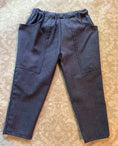Load image into Gallery viewer, The back view of the blue chambray pants showing the elastic waist and how the pockets go around to the back
