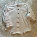 Load image into Gallery viewer, flat view of the white linen button down shirt showing the detail of the wood buttons, poet collar and monogram pocket. One sleeve is rolled up and buttoned with the tab from inside the shirt
