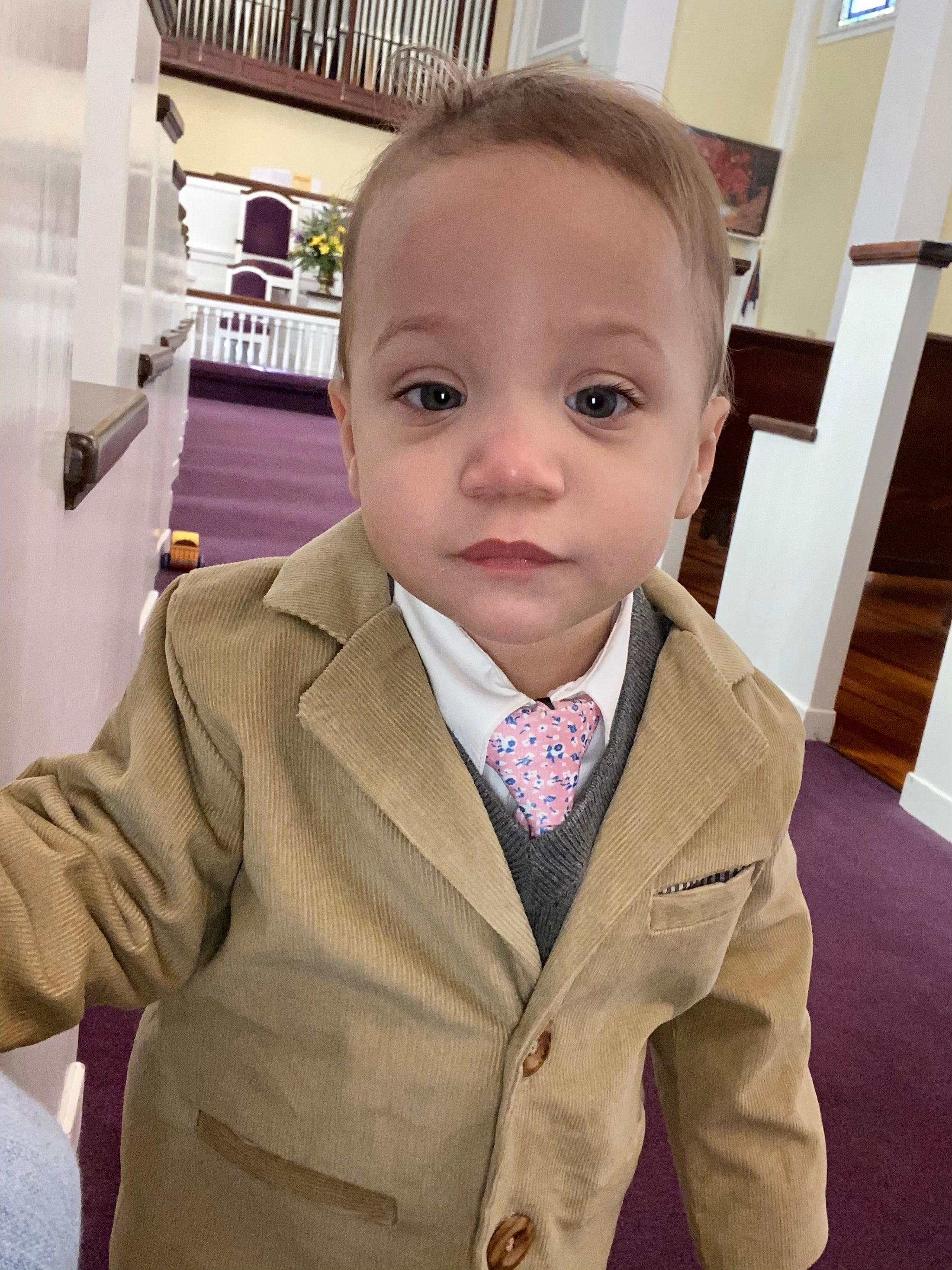 Closeup of toddler in church with tan corduroy sportscoat