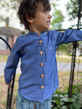 Load image into Gallery viewer, little boy in blue chambray button down shirt showing the monogram on the front pocket
