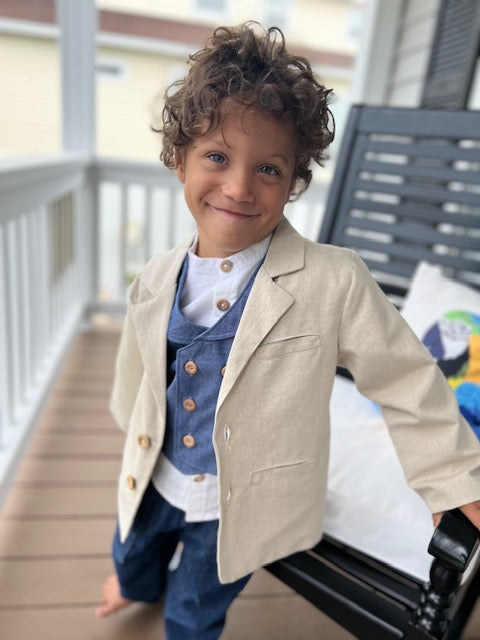 little boy with natural linen sportscoat, blue chambray double breasted waistcoat with wood buttons, white linen button down shirt with poet collar and blue chambray drawstring pants