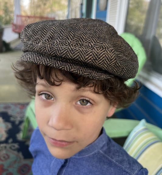 boy wearing a light and dark brown tweed newsboy cap