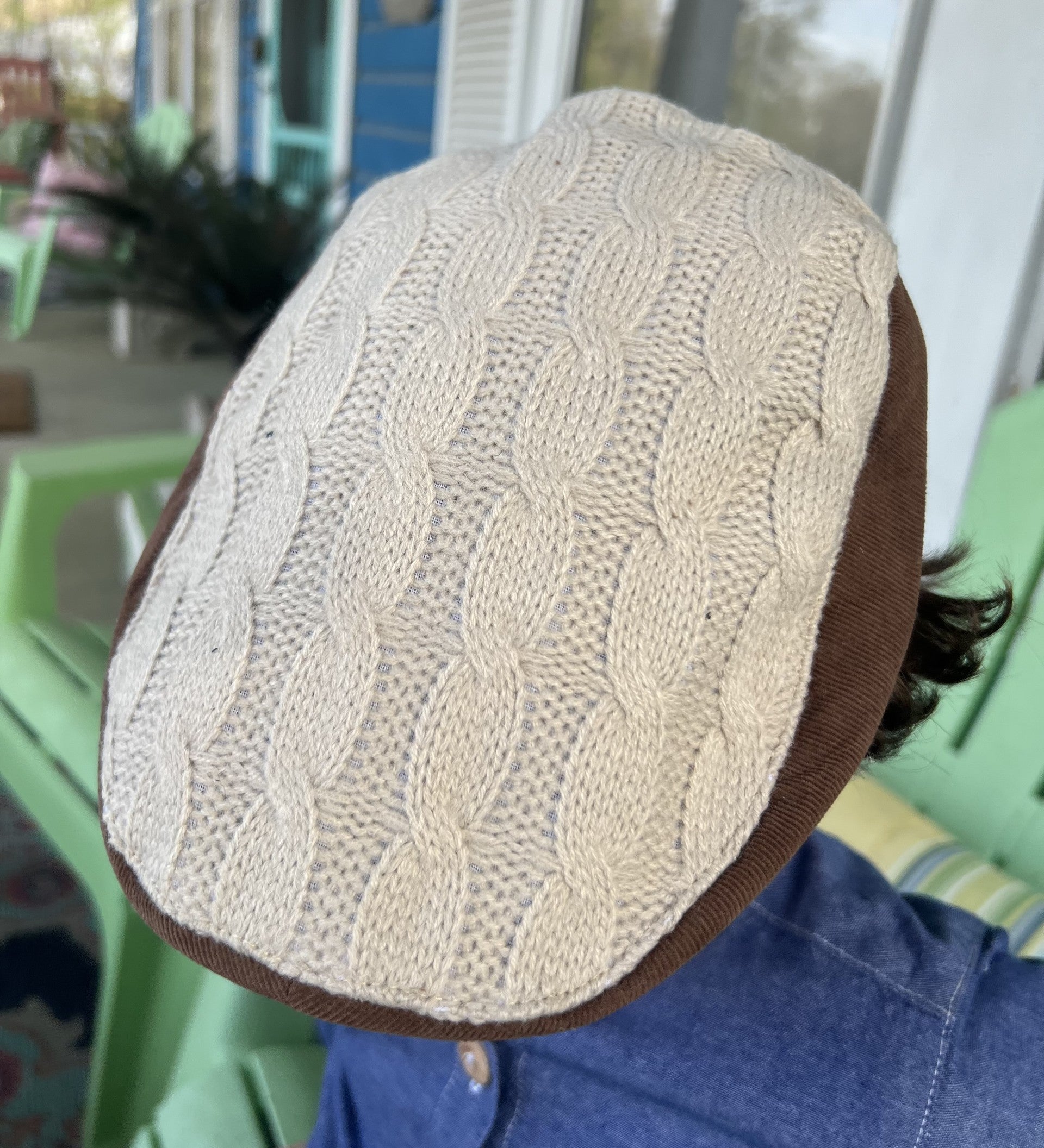 closeup view of the top of the newsboy cap showing the cream color knit 
